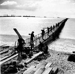 Men walking along the emergency pier for landing craft 