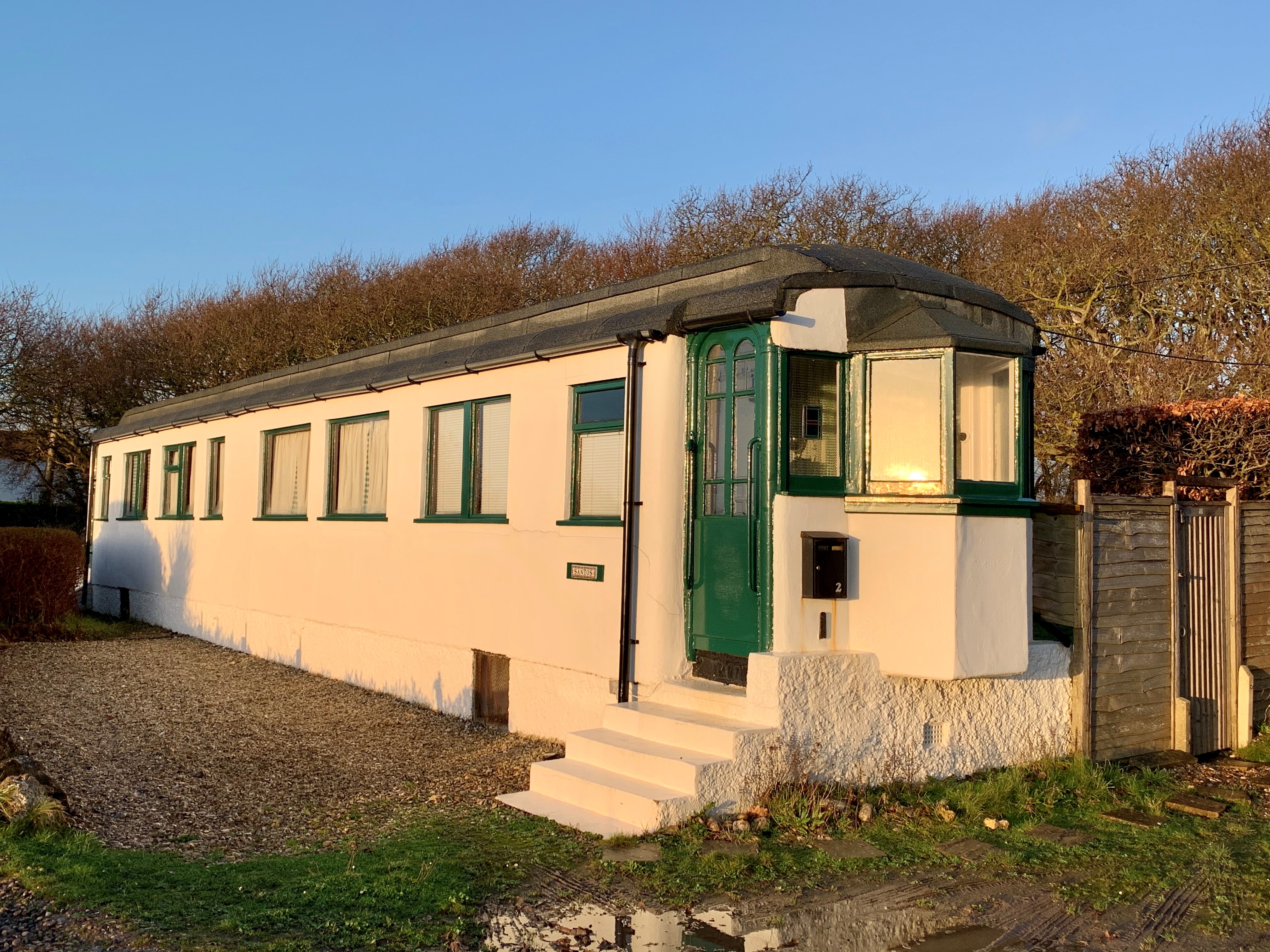 House made out of one railway carriage and rendered in concrete.