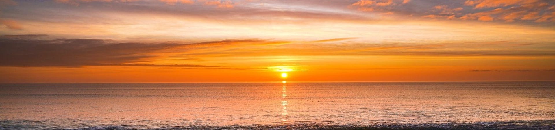 The sun rises over Pagham Harbour as the clouds radiate the light