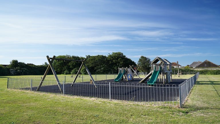 Image of the playground at Hillfield with swings, sides and climbing frame