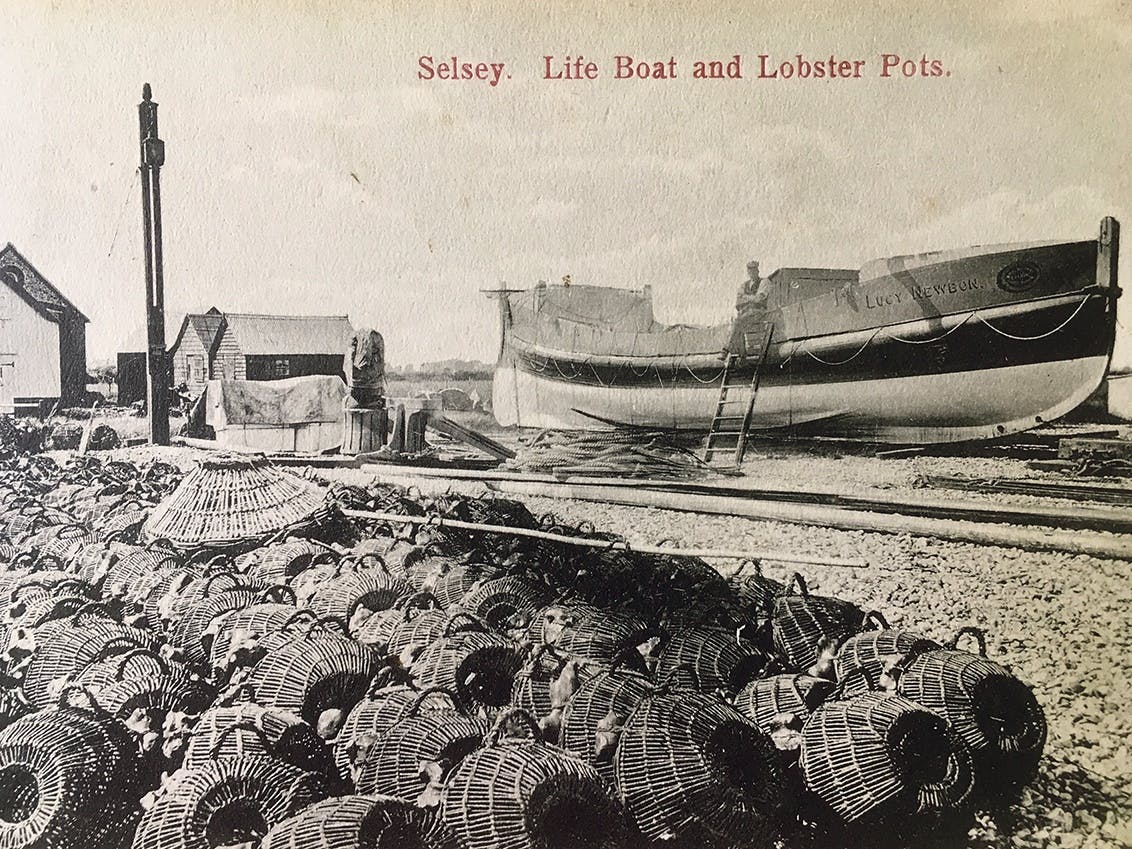 Selsey lifeboat Lucy Newborn in the background with hundreds of lobster pots lining the foreground of this black and white image