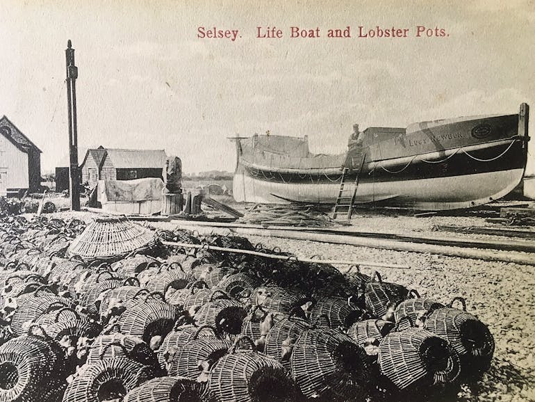 Lucy Newborn Lifeboat with hundreds of lobster pots lining the foreground,courtesy of West Sussex County Council Records Office,PP/WSL/PC006288 Selsey lifeboat Lucy Newborn in the background with hundreds of lobster pots lining the foreground of this black and white image