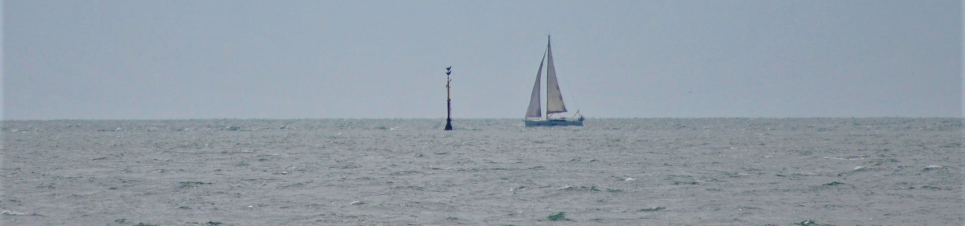 A sail boat next to the Mixon Marker, off East Beach, Selsey