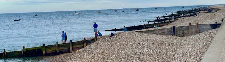 People gather to fish off of East Beach, Selsey