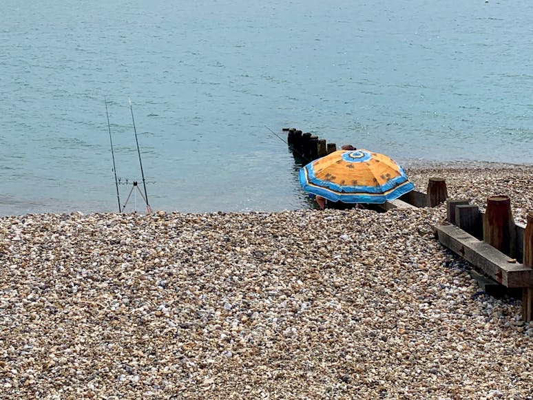 Fishing for the evening at East Beach Fisherman's rods and parasol on east beach, selsey