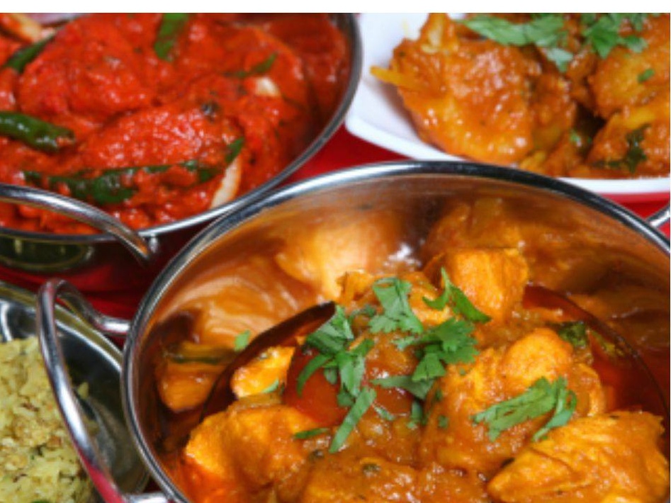 A selection of 3 different bowls of curry and rice at New Magna Tandoori Restaurant