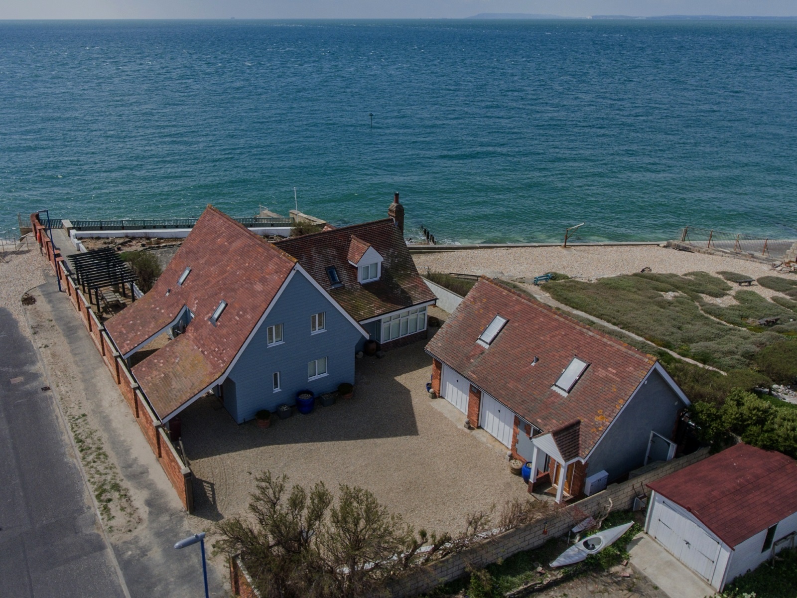 Aeria view of the beach house and its out buildings right by the open sea