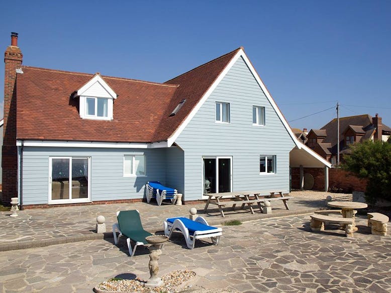 Sun terrace over looking the sea, courtesy of Selsey Beach House the back of the cladded house and sun deck
