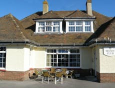Outside building of The Selsey Club Ltd with seating