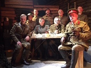 Image of 9 actors dressed in World War 1 uniforms acting out a scene from Journey's End