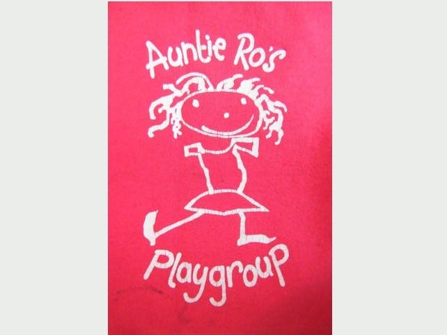 Auntie Ro's Playgroup logo made up of a red background with an artistic white outline of smiley child with the words Auntie Ro's Playgroup 