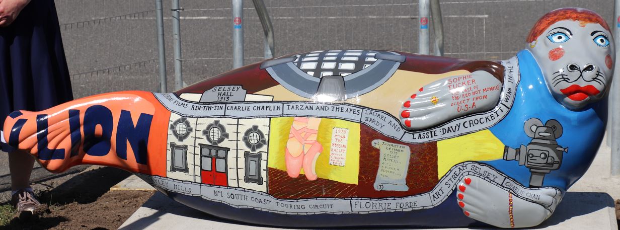 Fibregalss seal painted with imagery to celebrate Selsey's Pavillion and the early 20th Century performer Sophie Tucker. Designed by Freya Kate Betteridge with the seal's head added by Pamela Howard OBE