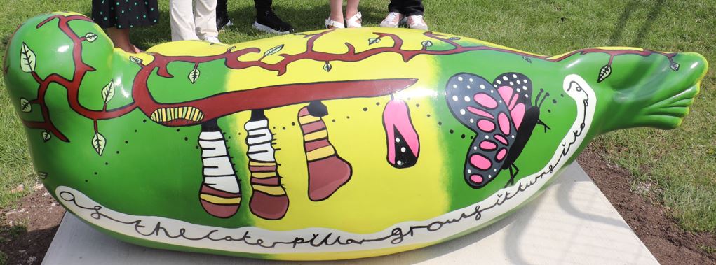 Back view of the bug hotel seal designed by Carleigh Barker and Rosie Harris, showing the life cycle from catepillar to butterfly
