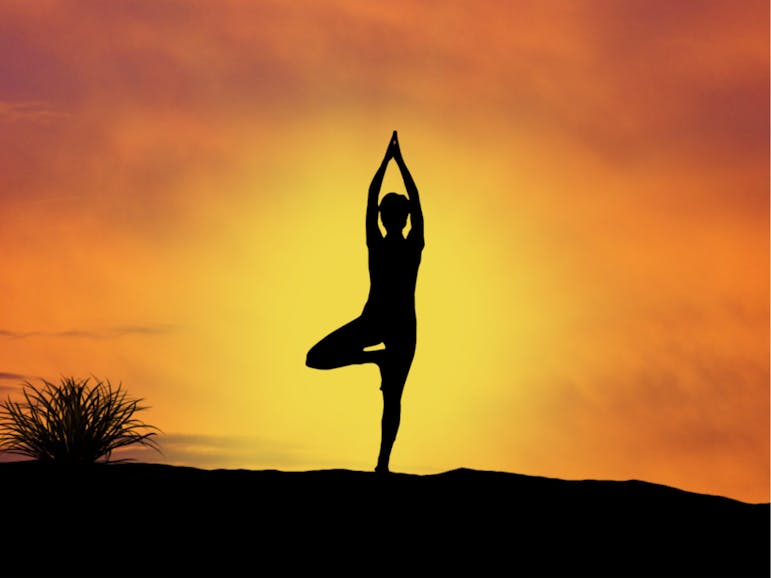 Yoga Siloutte of a person in a yoga pose with a sunrise/sunset backgound