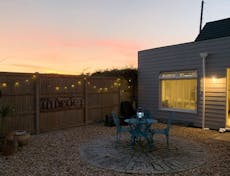 Evening photgraph of a courtyard area with table and four chairs