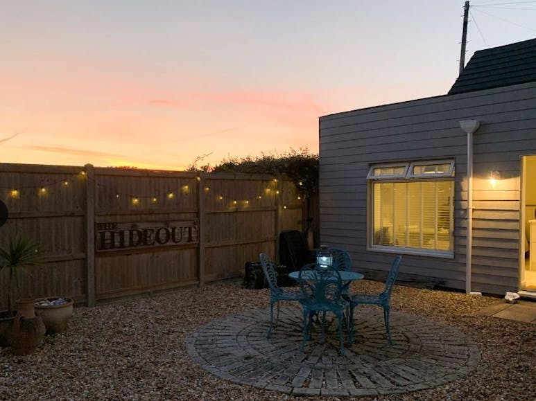 The Hideout Evening photgraph of a courtyard area with table and four chairs