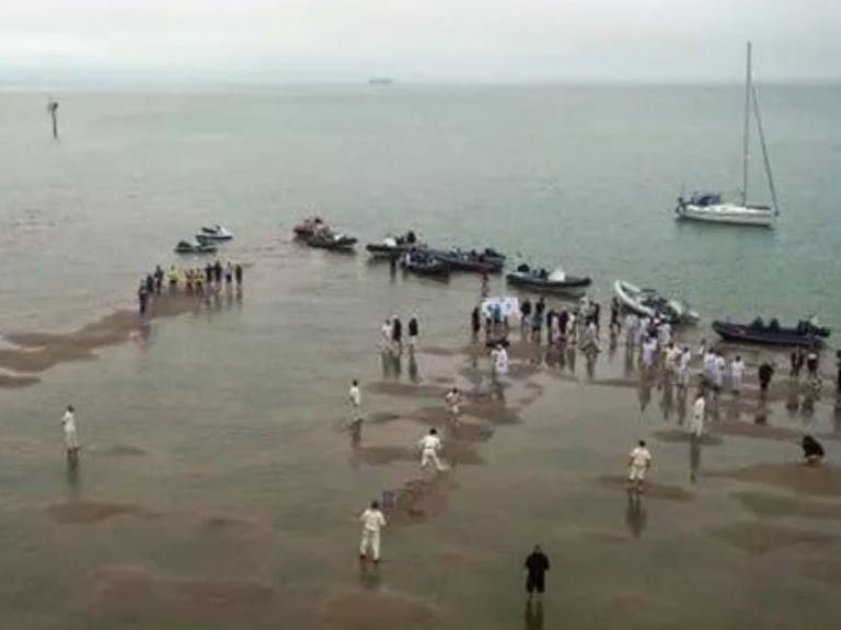 People playing a ball game at low tide