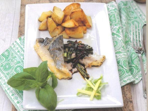 White, square plate with fillet of fish, choped potatoes and garnish
