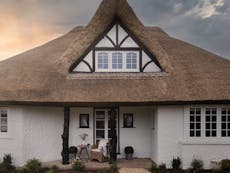 Photograph of a white, thatched cottage