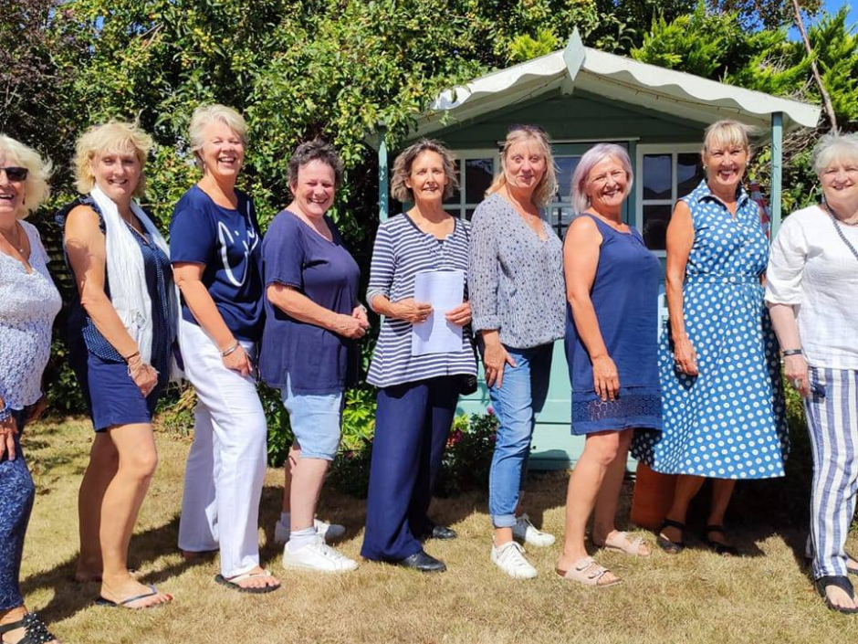 Photograph of nine women standding in a sunny garden