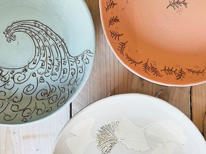 Photograph of three platters carved into using a sgraffito techinque