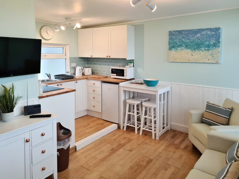 Internal photograph of a chalet with living area and small kitchen