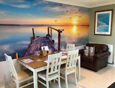 Photograph of a dining room with large sea themed feature wall