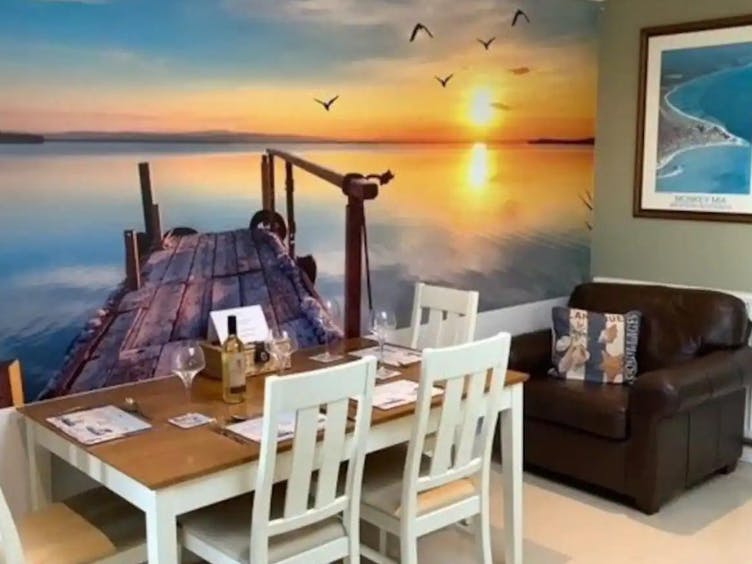 Photograph of a dining room with large sea themed feature wall