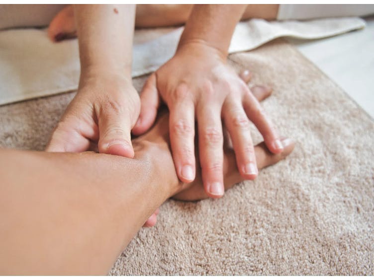 Photograph of hands massaging a hand and arm