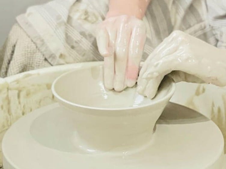 Photograph showing a pot being thrown on a Pottery wheel