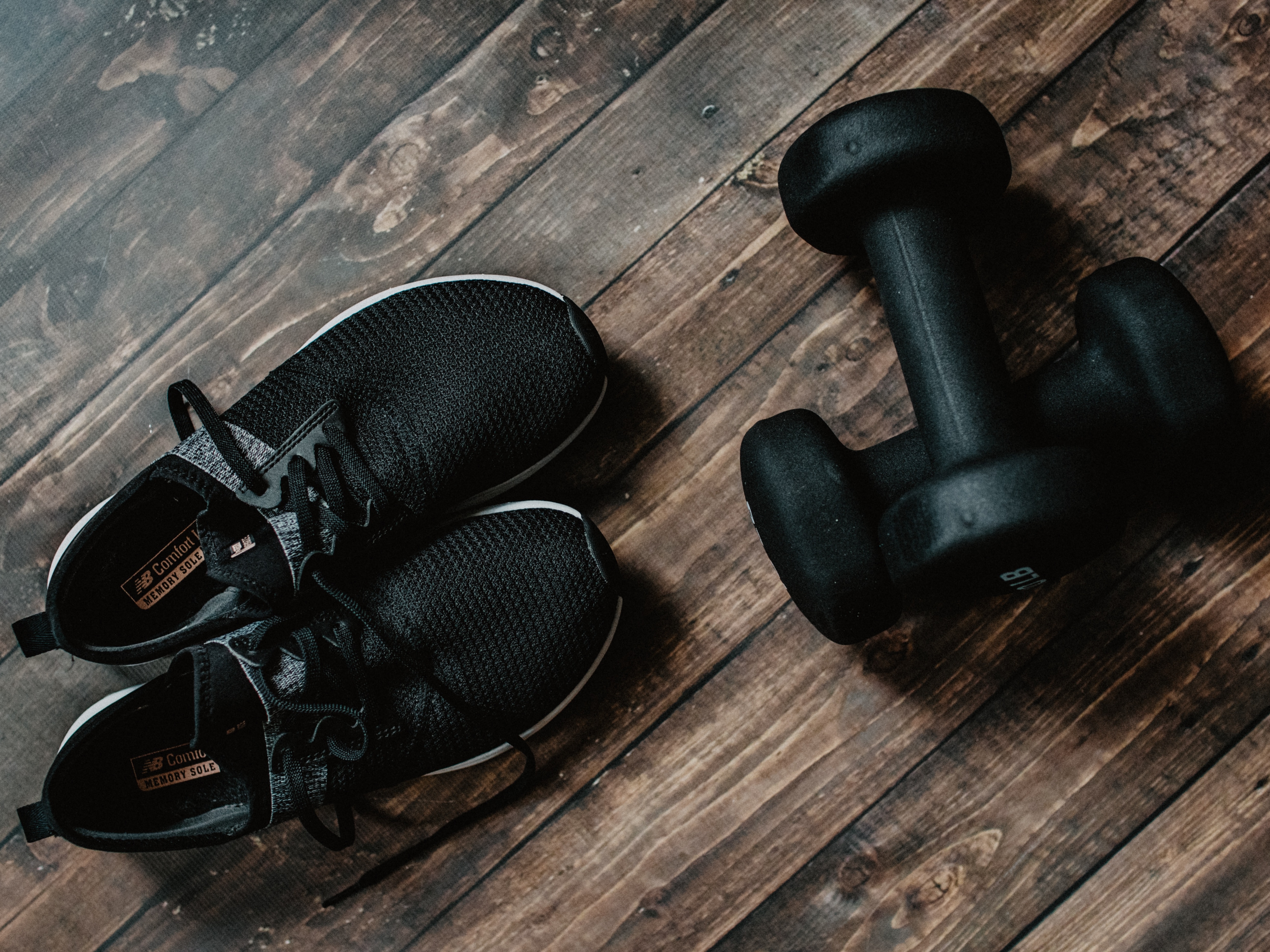 trainers and exercise weights on a wooden floor