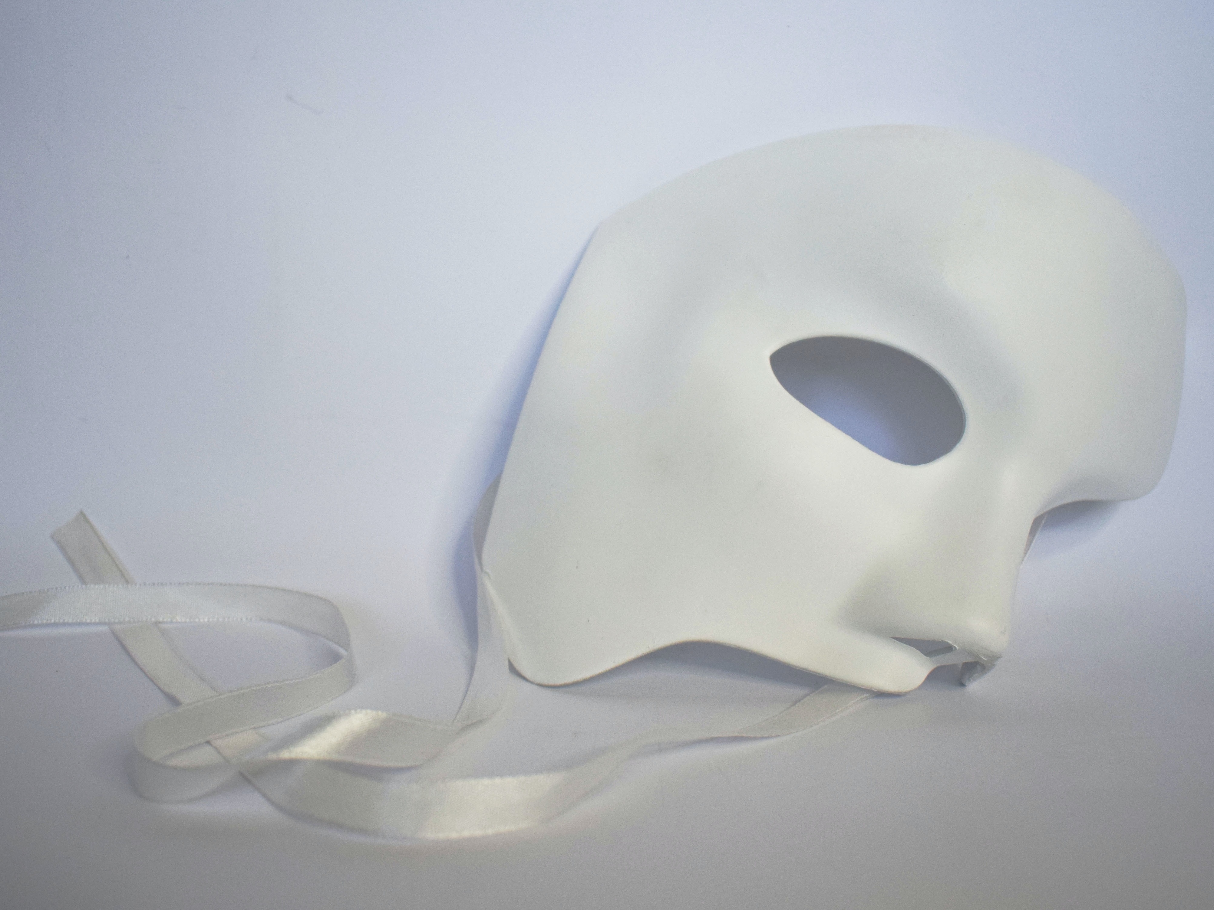 Image of a white theatre mask with ribbens