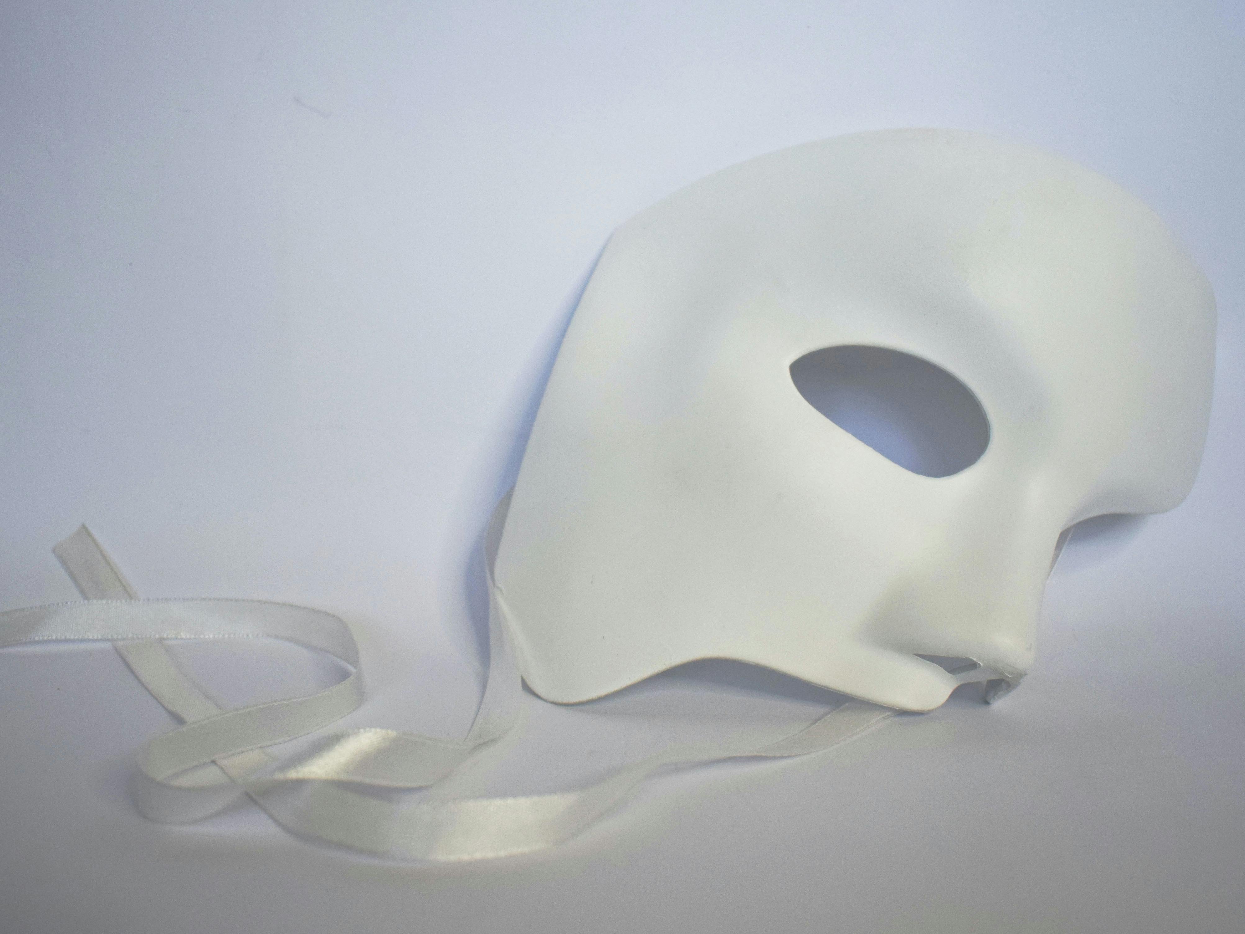 Image of a white theatre mask with ribbens