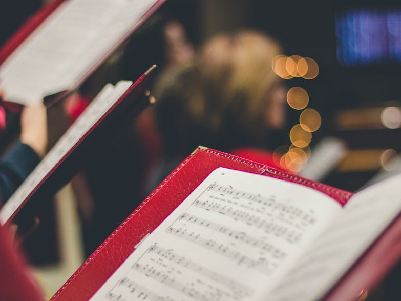 Image courtesy of David Beals on Unsplash Photograph of a sheet of music with blurred lights inthe background