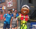 Photo of four individuals and RNLI Selsey's bearded mascot outside Selsey Lifeboat Station