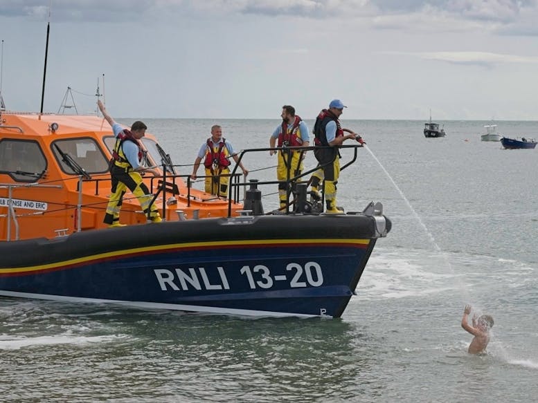 Selsey Lifeboat Fun! courtesy of RNLI Selsey Photograph of lifeboat crew spraying sea water onto a young child