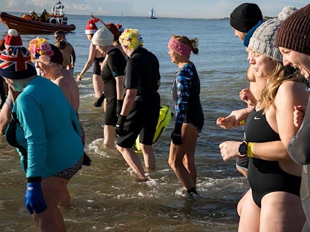 Photograph of sea bathers in Selsey witht the Selsey Lifeboat in the background