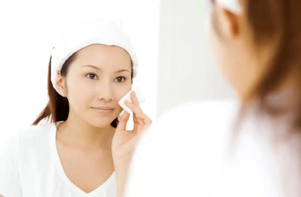 woman cleaning her face