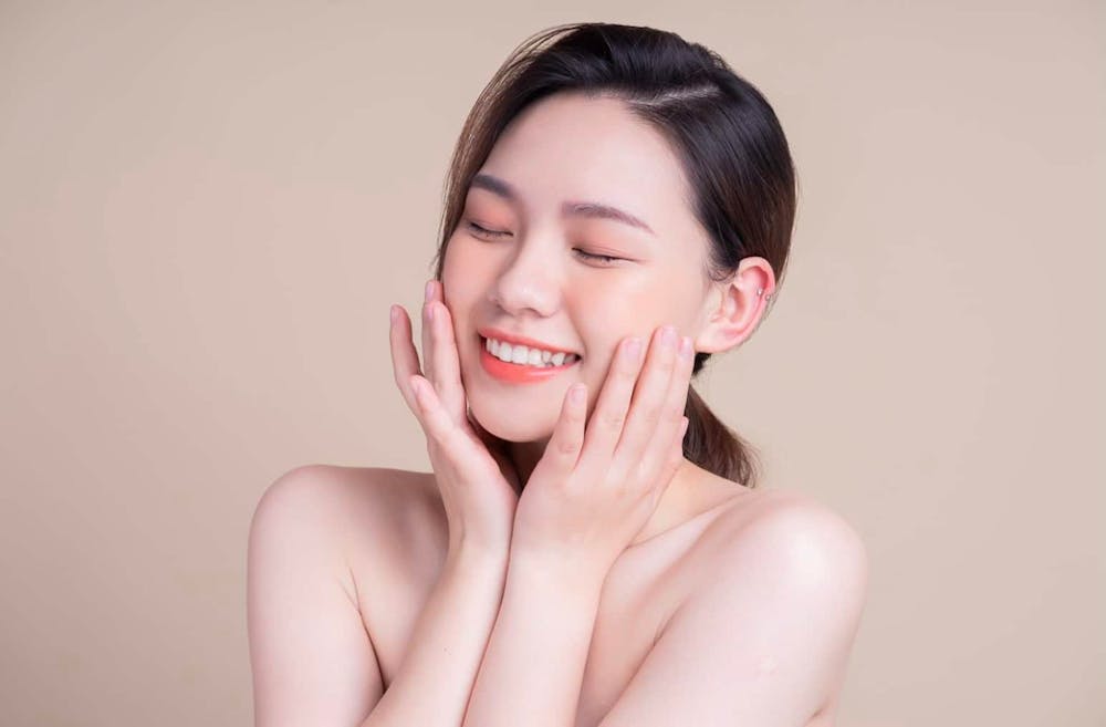 woman touching her face and smiling