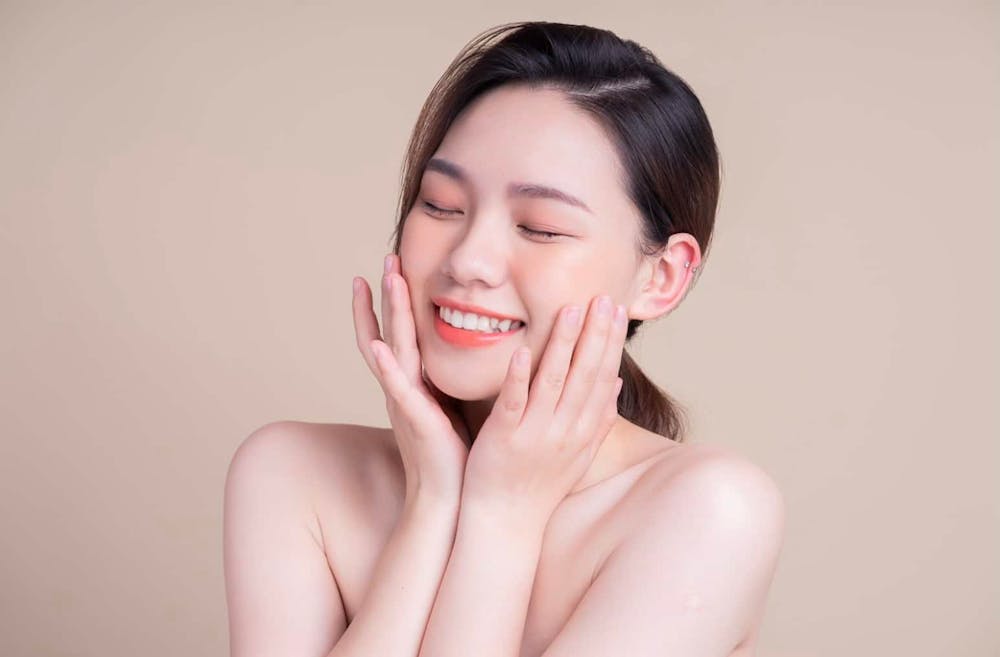 woman touching her face and smiling
