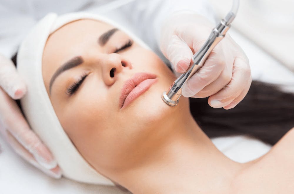 A woman receiving a skin care treatment with a high-tech device for facial rejuvenation, as part of a beauty treatment.