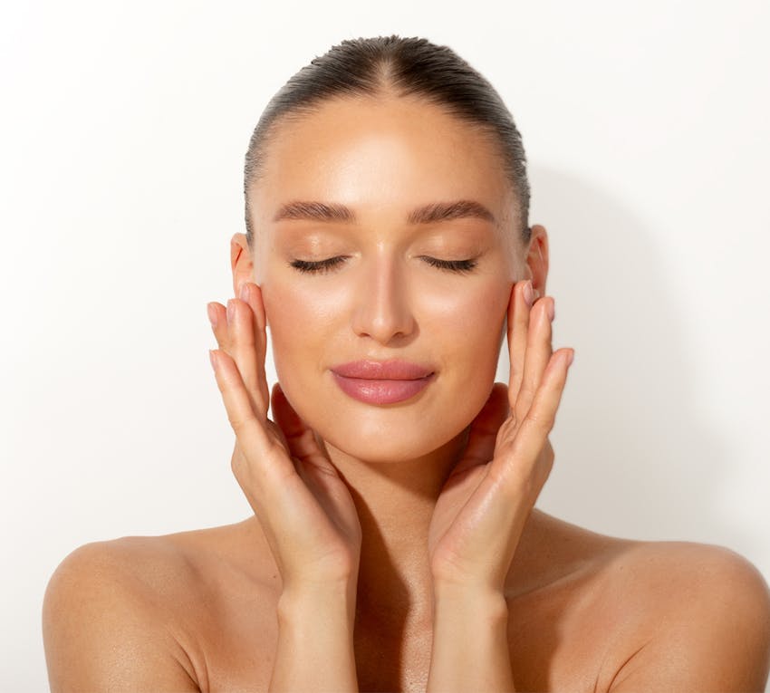 woman gently touching her face with eyes closed