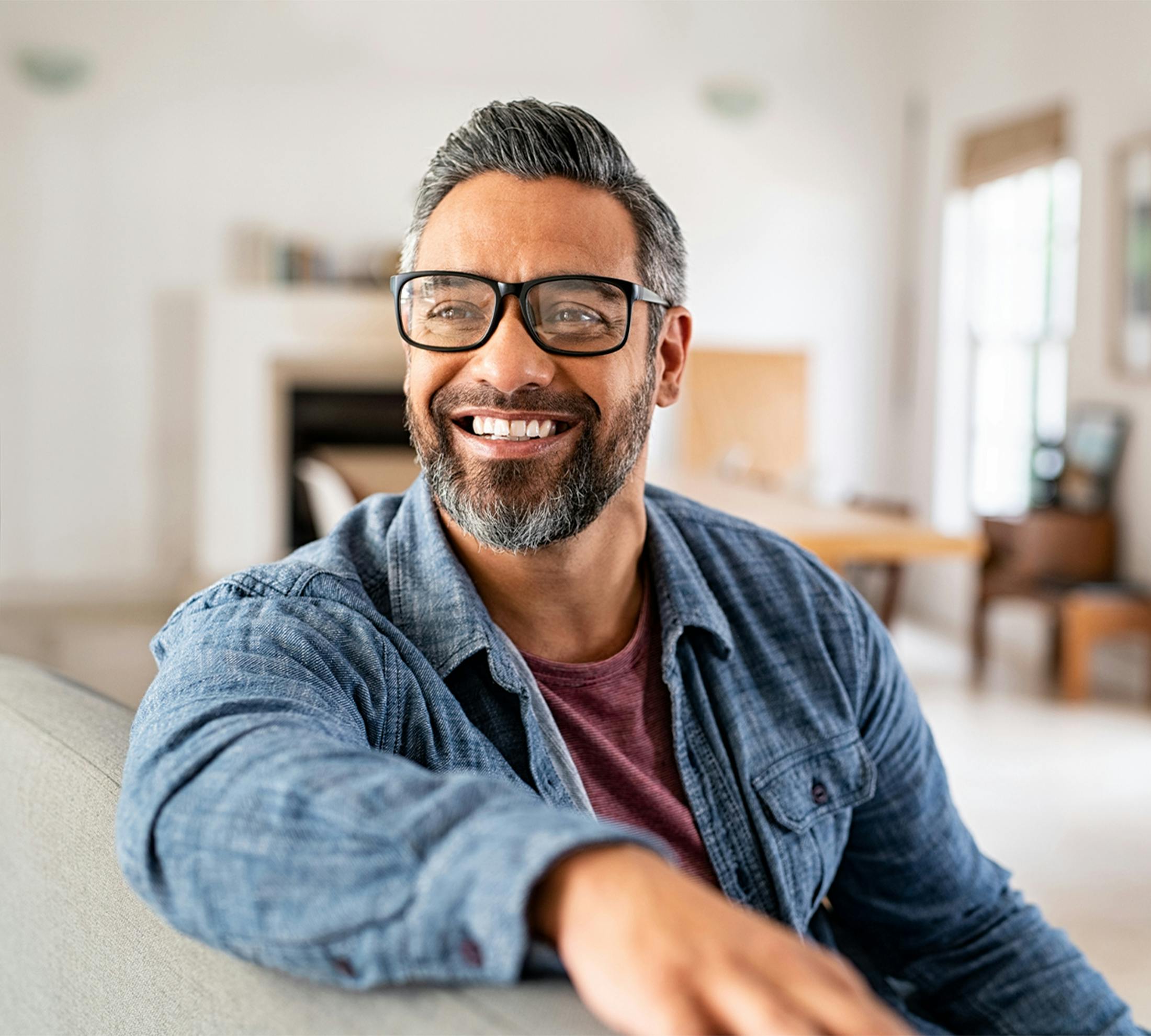 man sitting on a couch, smiling