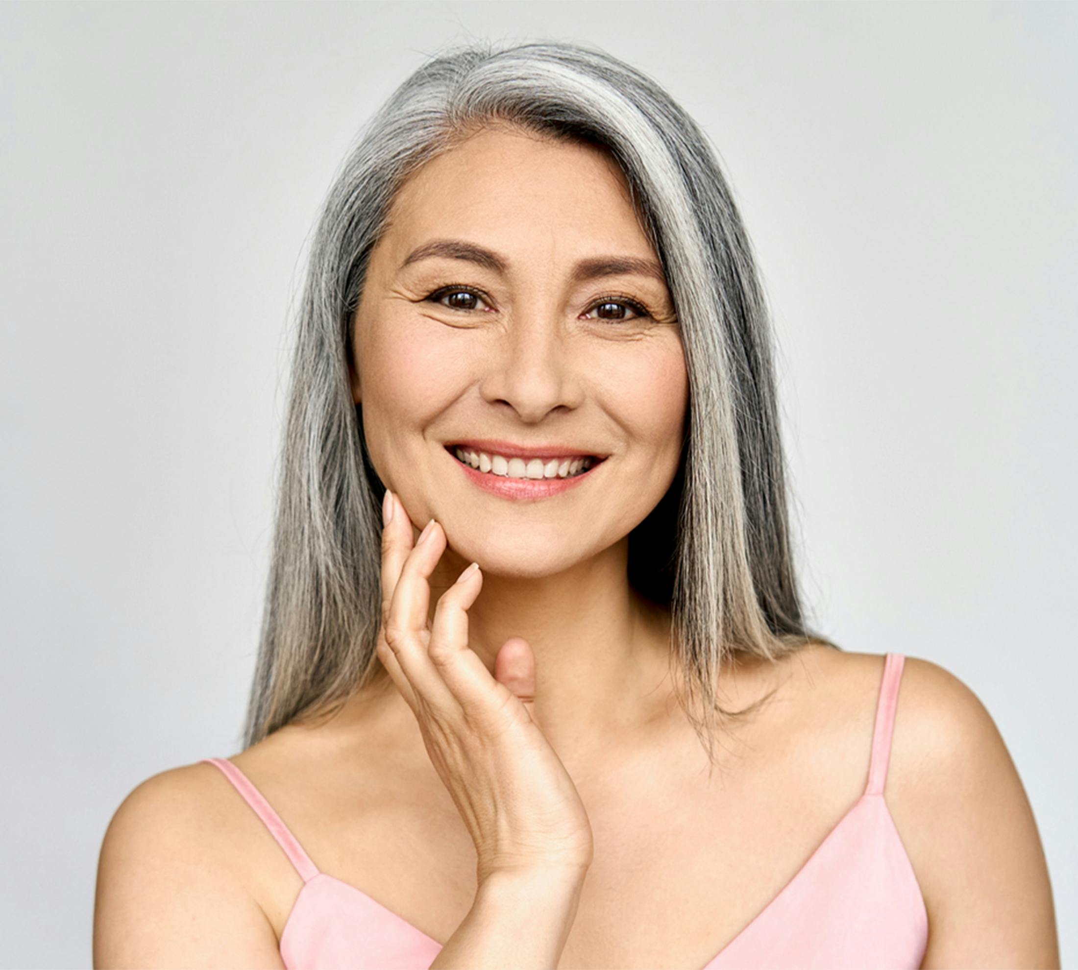 Woman smiling and touching her face