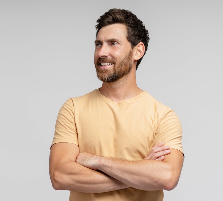 man crossing arms smiling off to the side