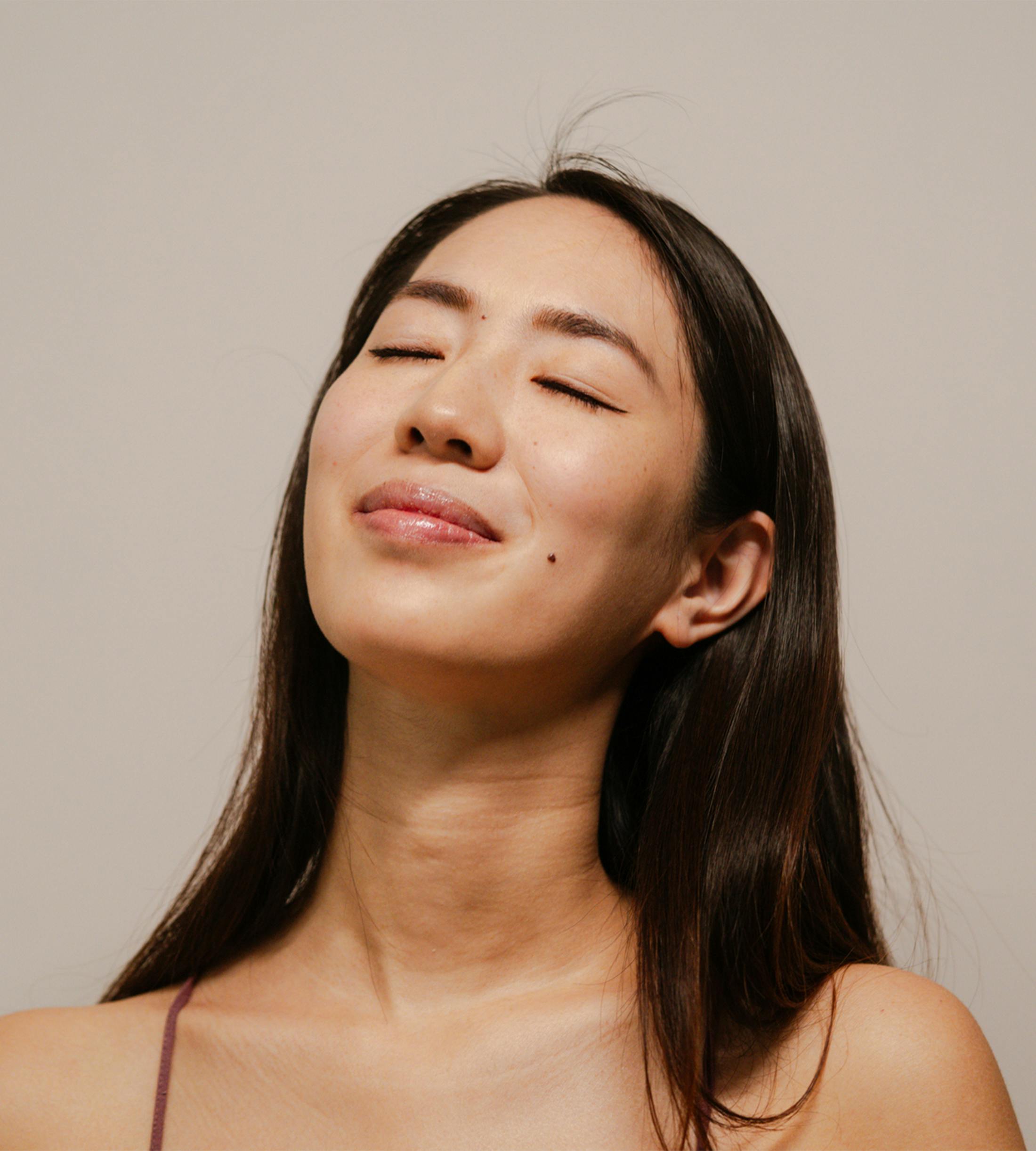 woman with closed eyes tilting her head up