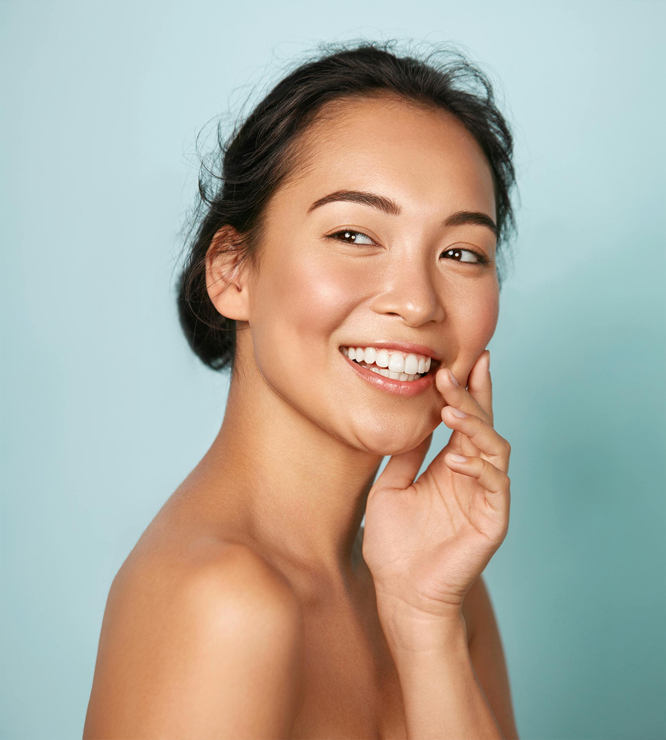 women smiling with hand on cheek