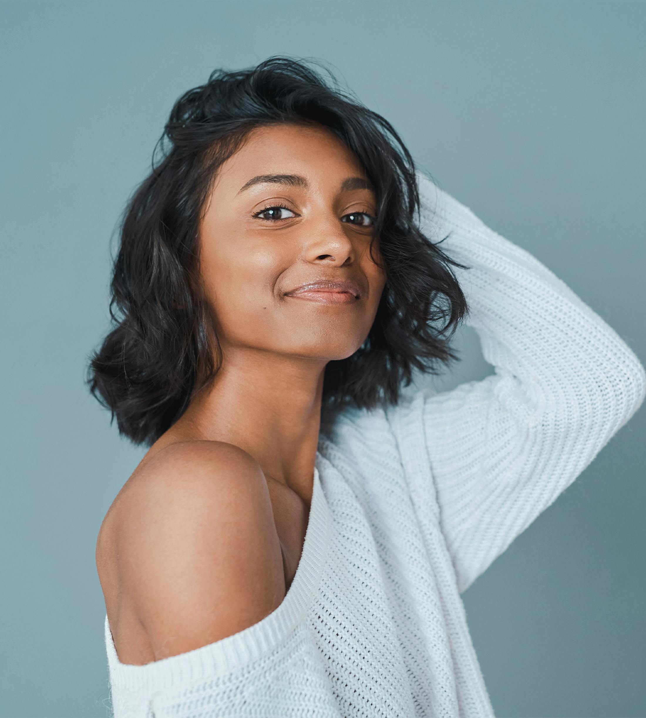 woman smiling with hand in hair