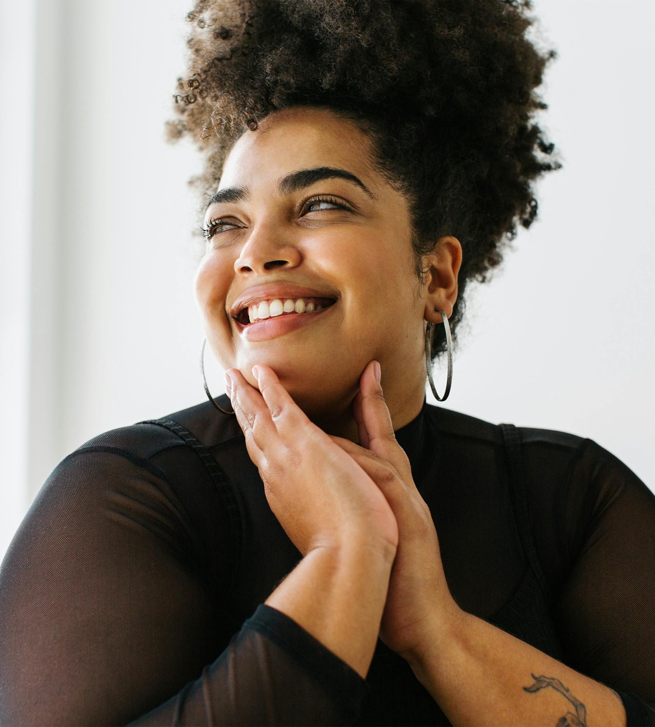 woman smiling with hands on chin