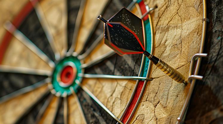 Close-up of a dart stuck in the outer ring of a dartboard, well off the bullseye
